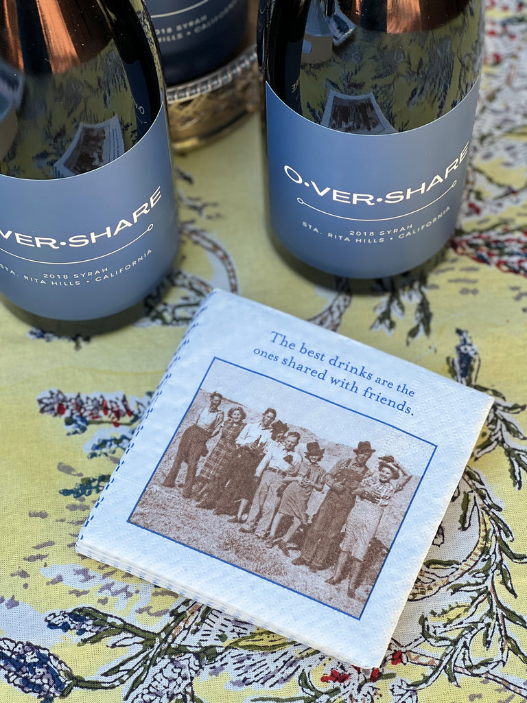 Overshare wine bottles and a napkin about sharing drinks with friends, original website photograph